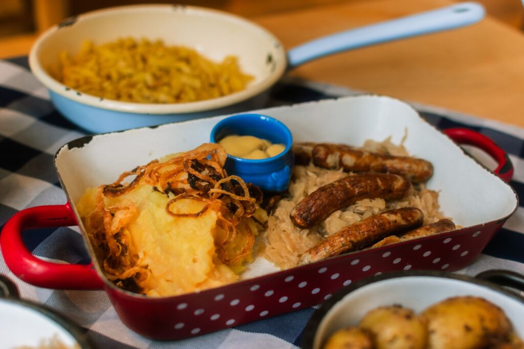 Delicious German sausages with potatoes, sauerkraut, and mustard in a rustic setting.