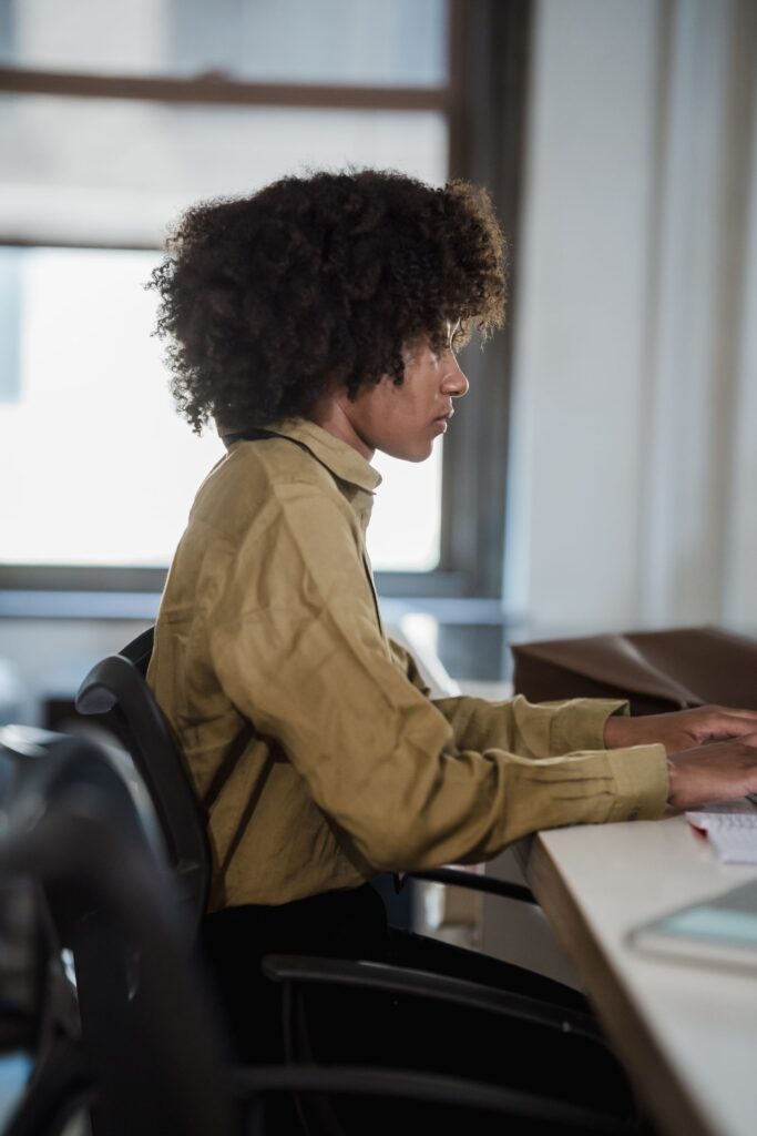 Focused woman working diligently at a desk in a modern office environment.