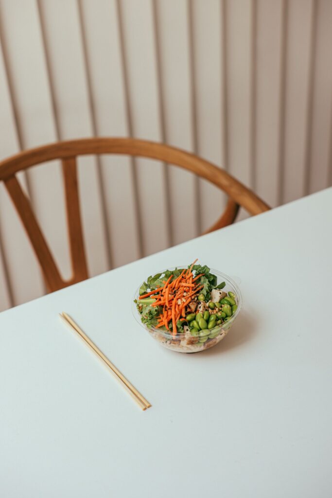 A fresh and colorful salad with chopsticks in a minimalist dining setting.