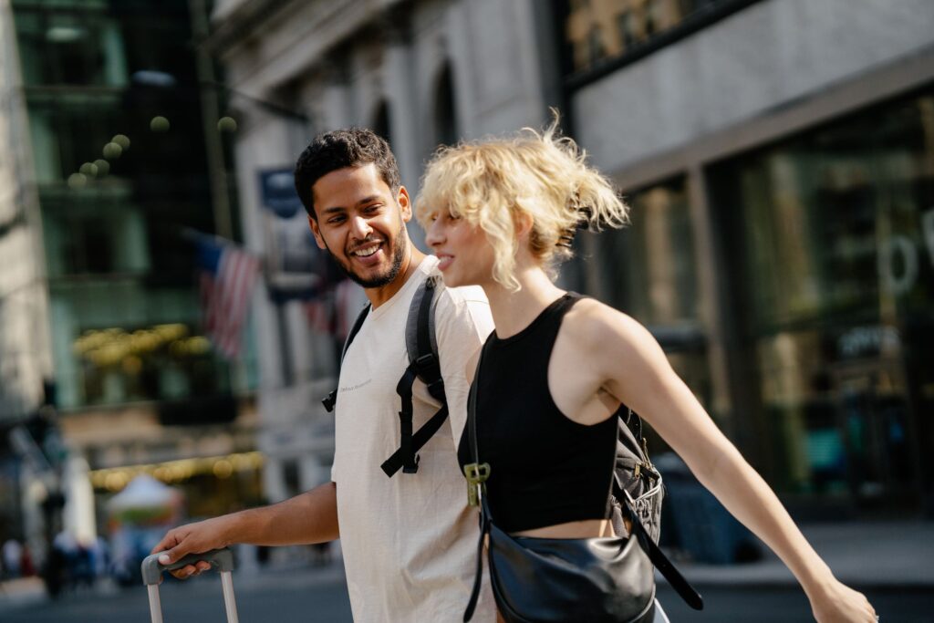 A man and a woman joyfully strolling through urban streets, capturing city life excitement.