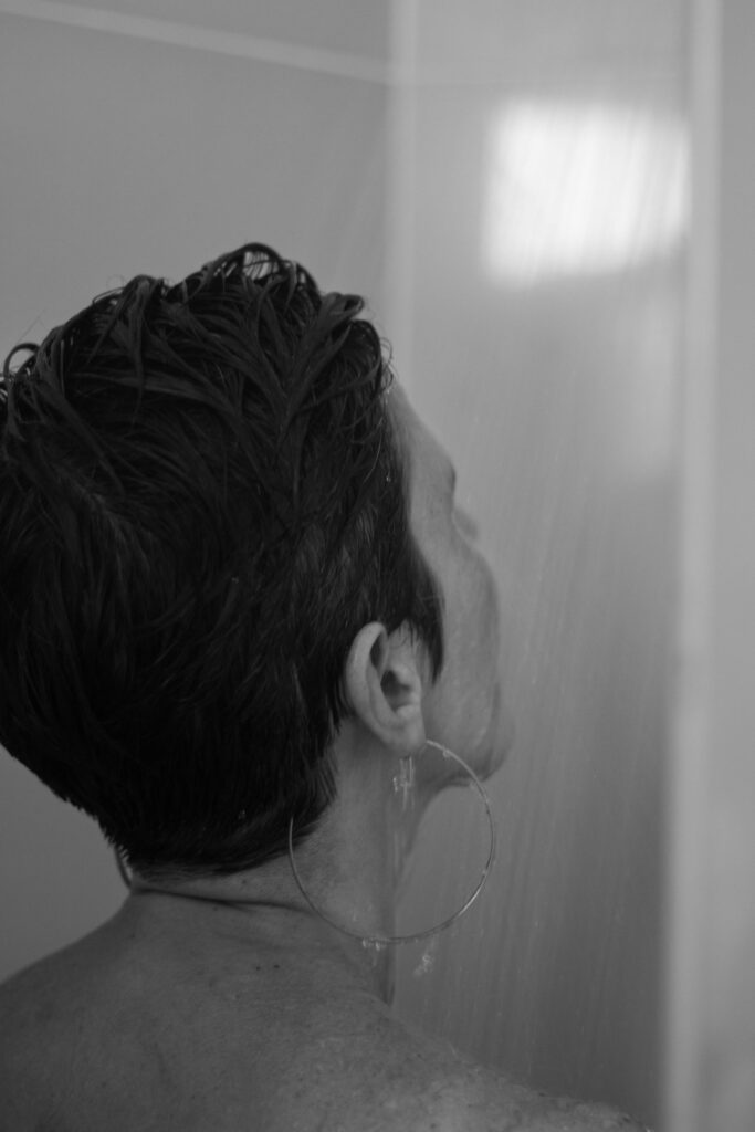 Artistic black and white portrait of a woman showering.