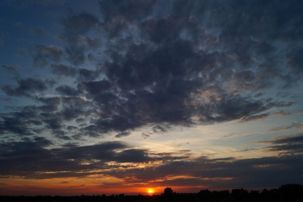 Beautiful sunset with dramatic clouds creating a moody, scenic atmosphere.