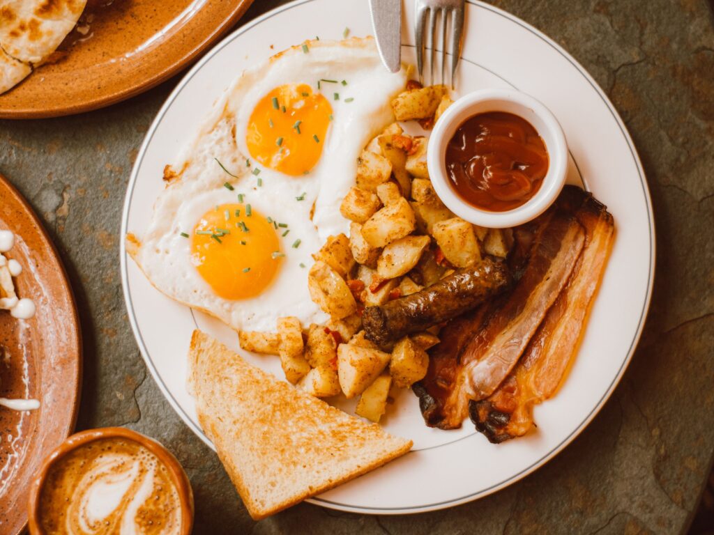 Delicious breakfast plate with sunny side up eggs, bacon, and toast.