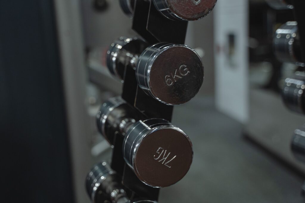 Metal dumbbells neatly arranged in a gym setting, ideal for fitness enthusiasts.