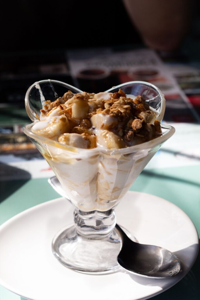 Tasty granola parfait with bananas and yogurt served in a glass dish, perfect for breakfast.